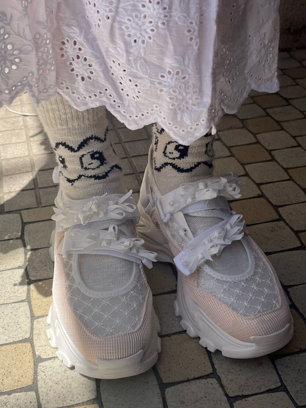 ホワイト系のショルダーバッグ、ホワイト系のスカート、ピンク系のTシャツ/カットソーを着用したレディースの春コーディネートの6枚目の写真