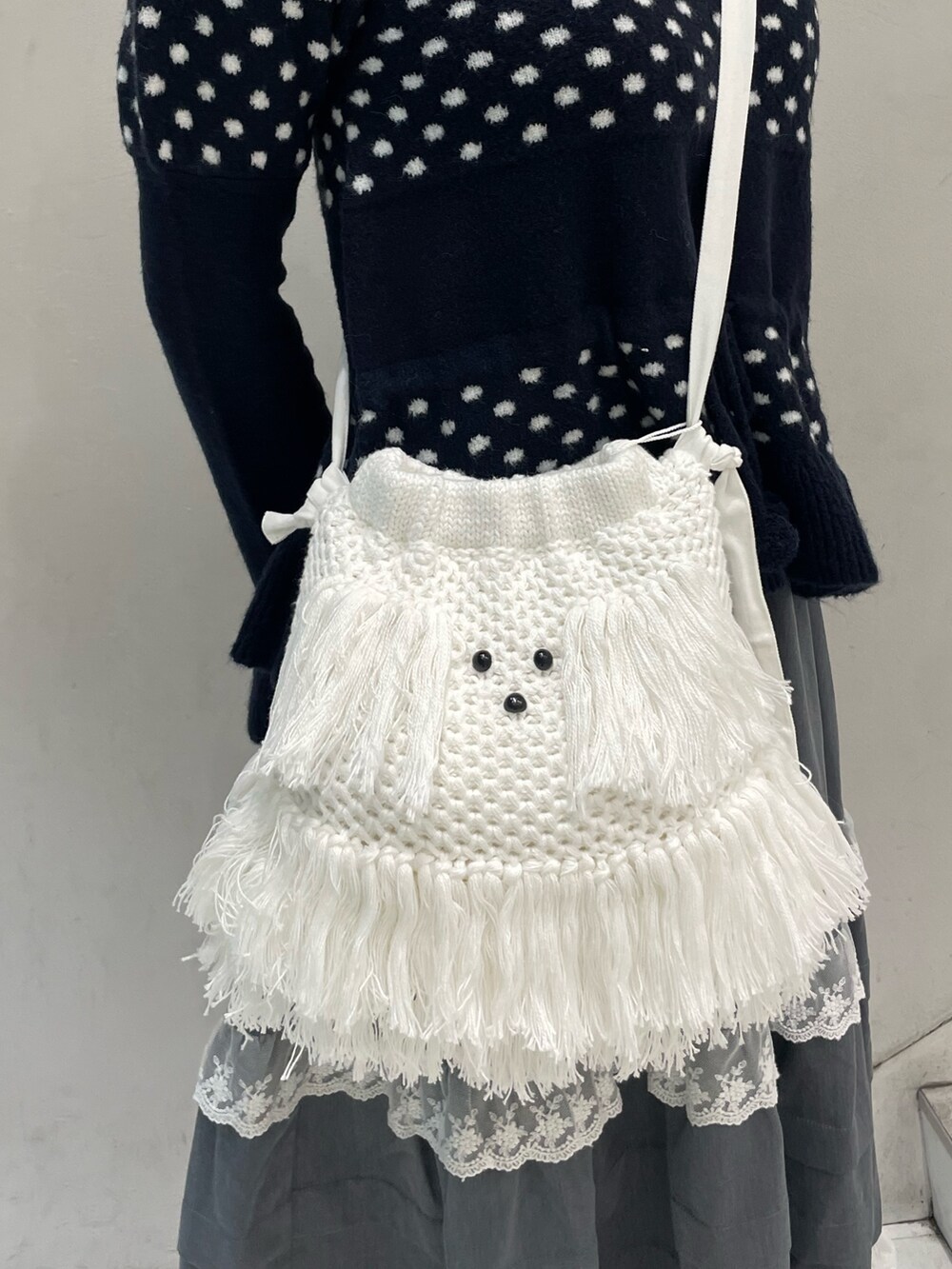 ブルー系のニット/セーター、グレー系のスカート、ホワイト系のショルダーバッグを着用したレディースの秋コーディネートの8枚目の写真