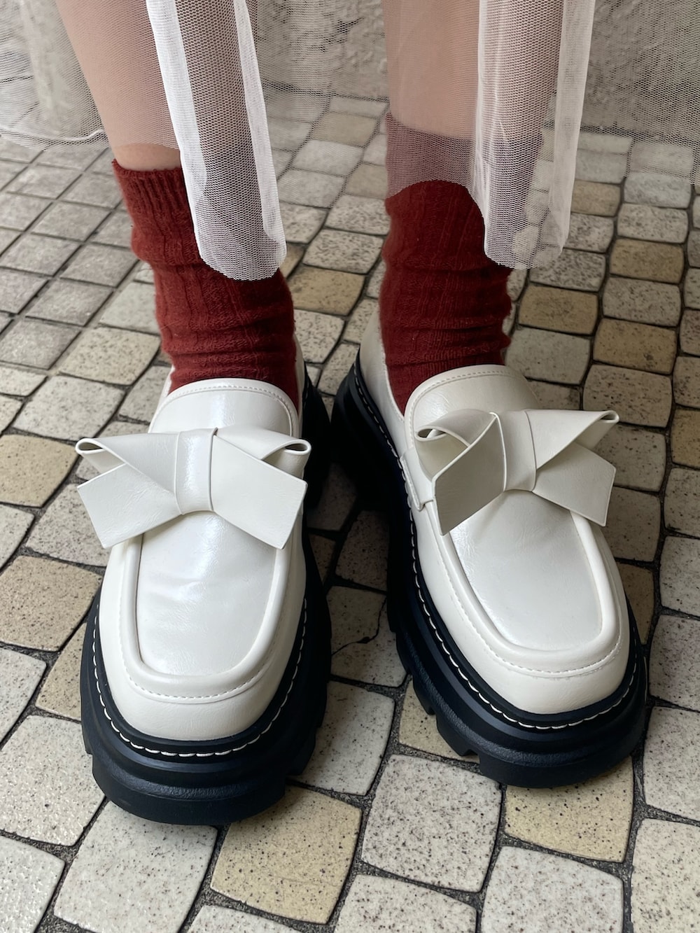 ホワイト系のニット/セーター、ピンク系のワンピース、ホワイト系のショルダーバッグを着用したレディースの冬コーディネートの7枚目の写真