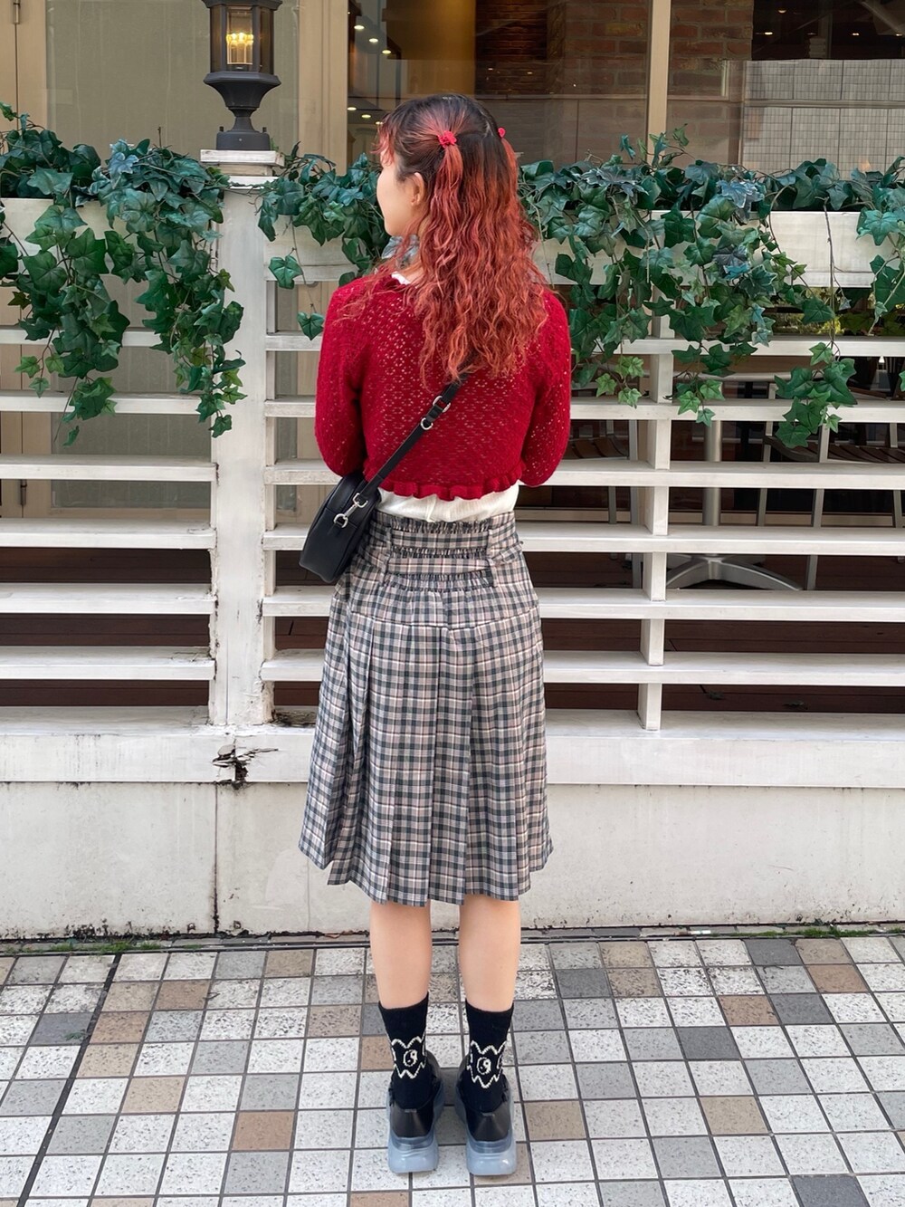 ブラック系のスニーカー、ホワイト系のTシャツ/カットソー、レッド系のカーディガン/ボレロを着用したレディースの春コーディネートの3枚目の写真