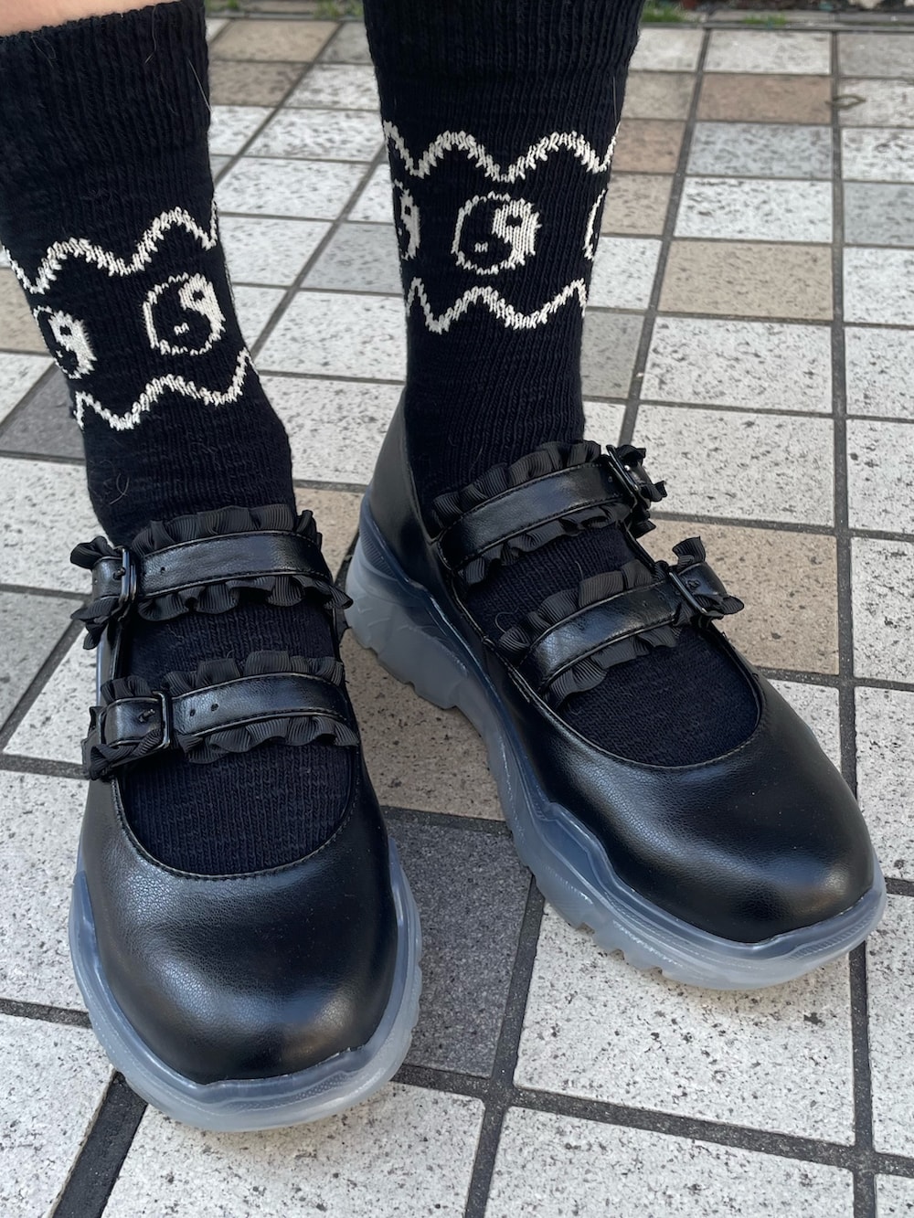 ブラック系のスニーカー、ホワイト系のTシャツ/カットソー、レッド系のカーディガン/ボレロを着用したレディースの春コーディネートの6枚目の写真