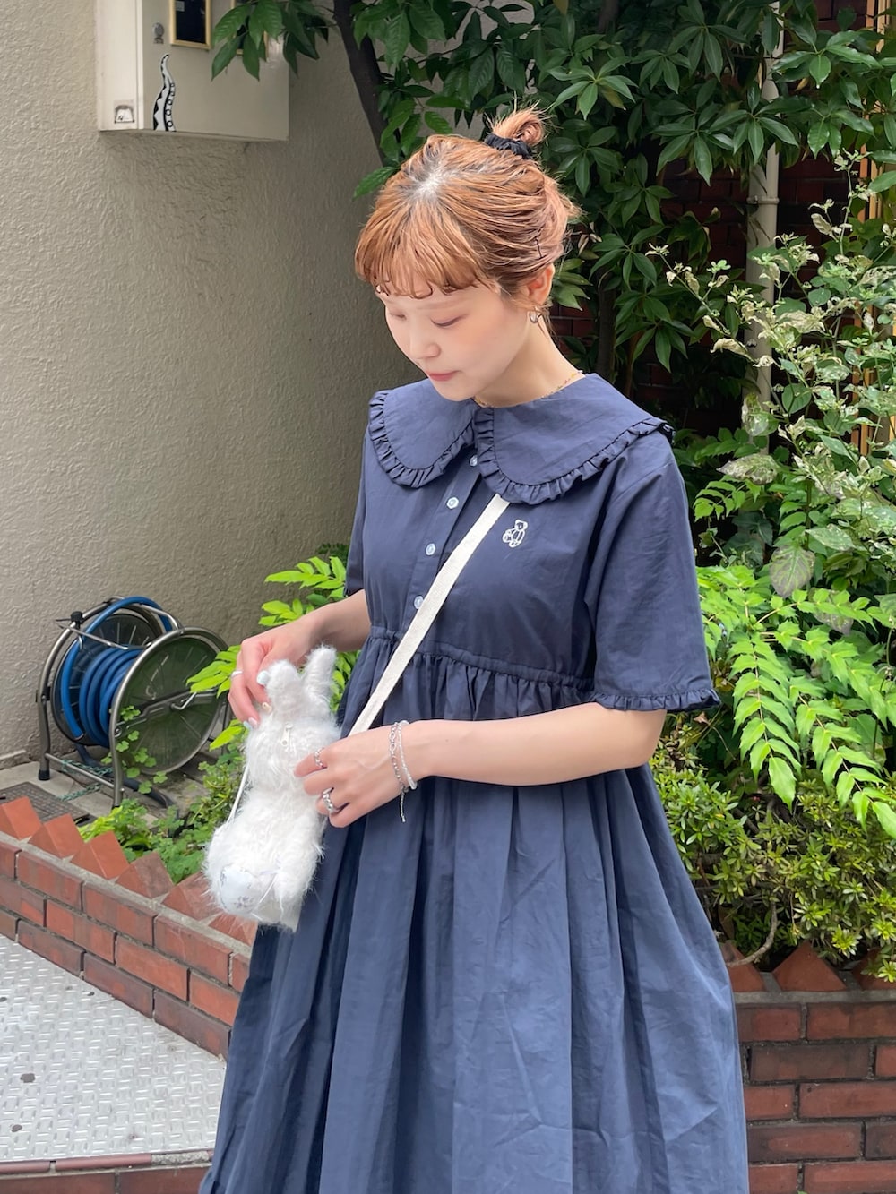 ブルー系のワンピース、ブラック系のスニーカー、ホワイト系のショルダーバッグを着用したレディースの夏コーディネートの6枚目の写真