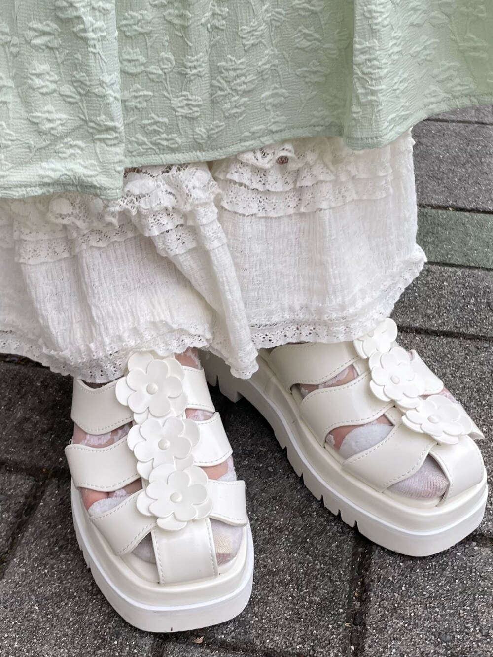 グリーン系のワンピース、ブルー系のキャミソール、ホワイト系のカーディガン/ボレロを着用したレディースの夏コーディネートの6枚目の写真