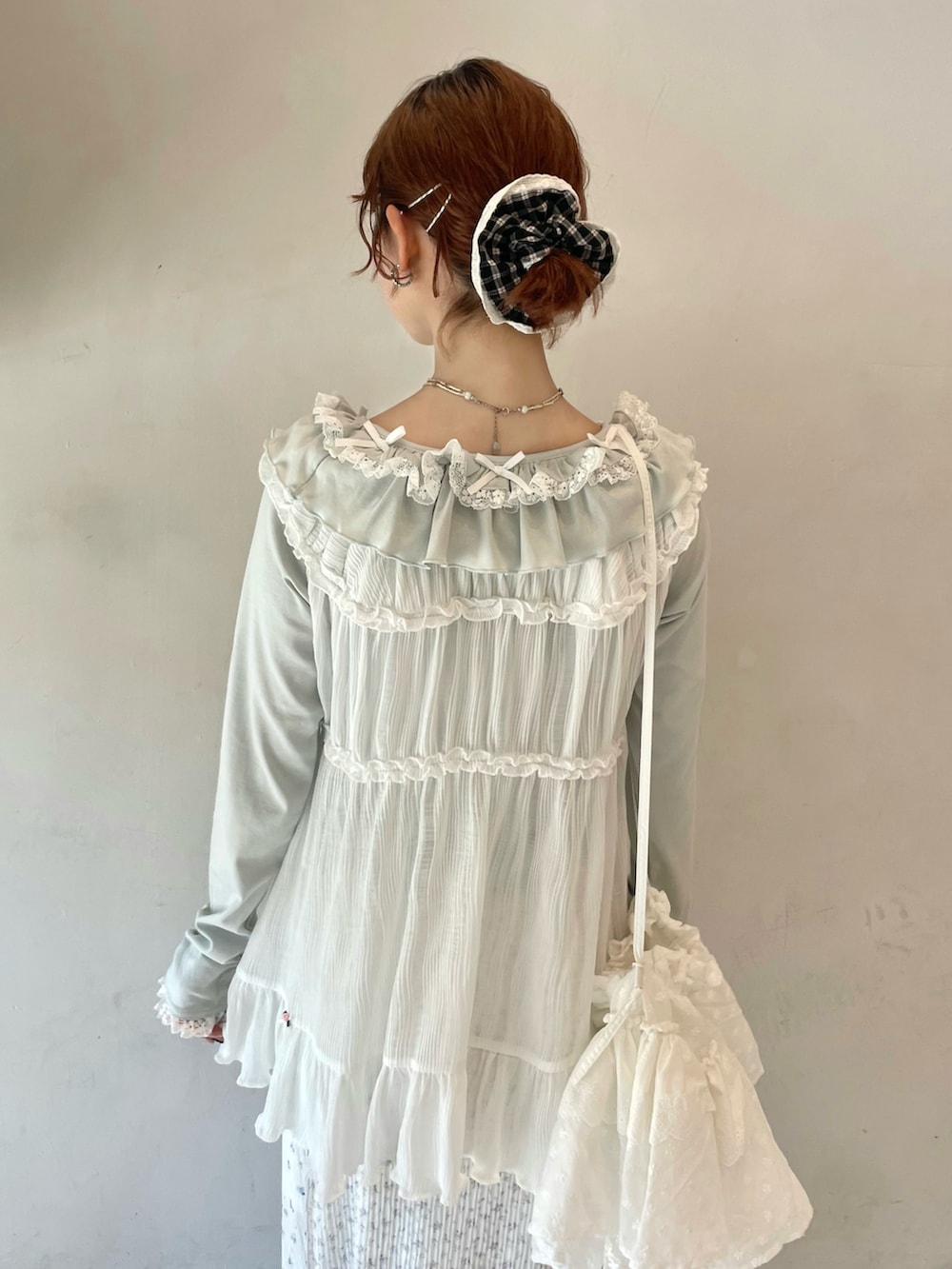 グリーン系のTシャツ/カットソー、ホワイト系のチュニック、ブルー系のスニーカーを着用したレディースの春コーディネートの5枚目の写真