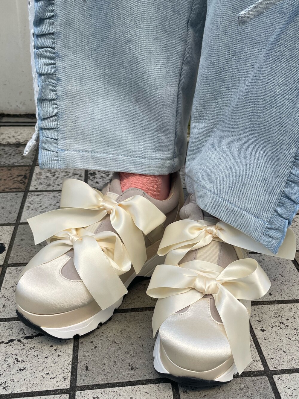 ブルー系のデニムパンツ、ホワイト系のスニーカー、ピンク系のTシャツ/カットソーを着用したレディースの夏コーディネートの7枚目の写真