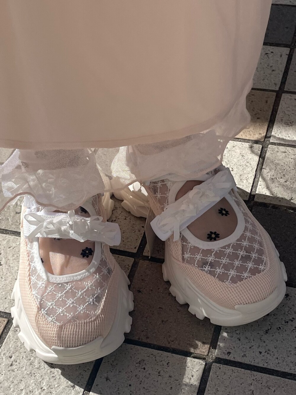 ピンク系のワンピース、ホワイト系のスウェット、ホワイト系のショルダーバッグを着用したレディースの冬コーディネートの8枚目の写真