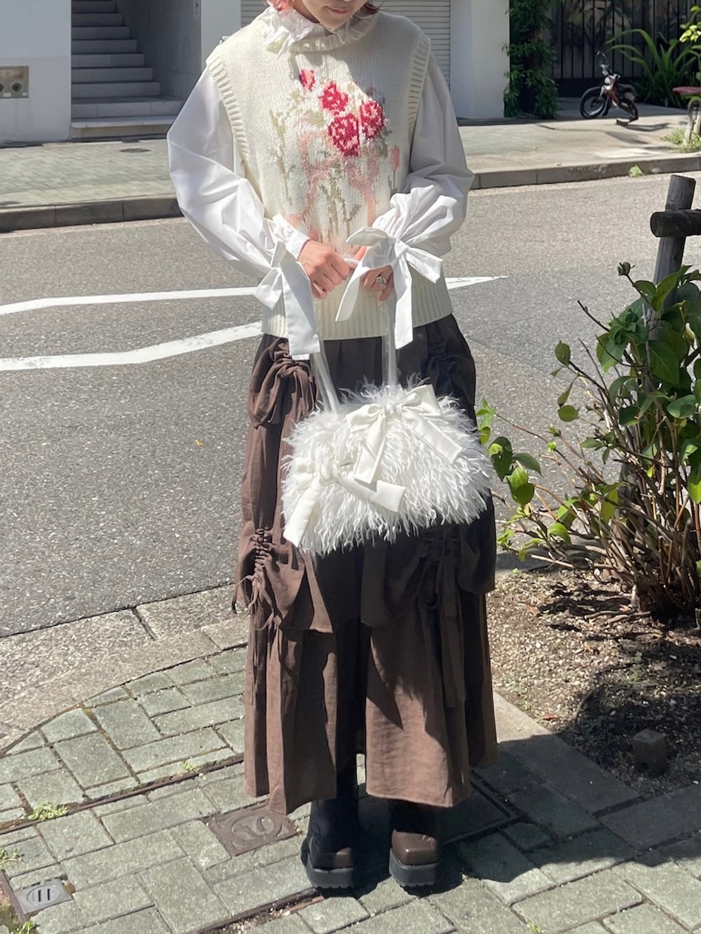 ホワイト系のボストンバッグ、ホワイト系のベスト、ホワイト系のシャツ/ブラウスを着用したレディースの秋コーディネートの2枚目の写真