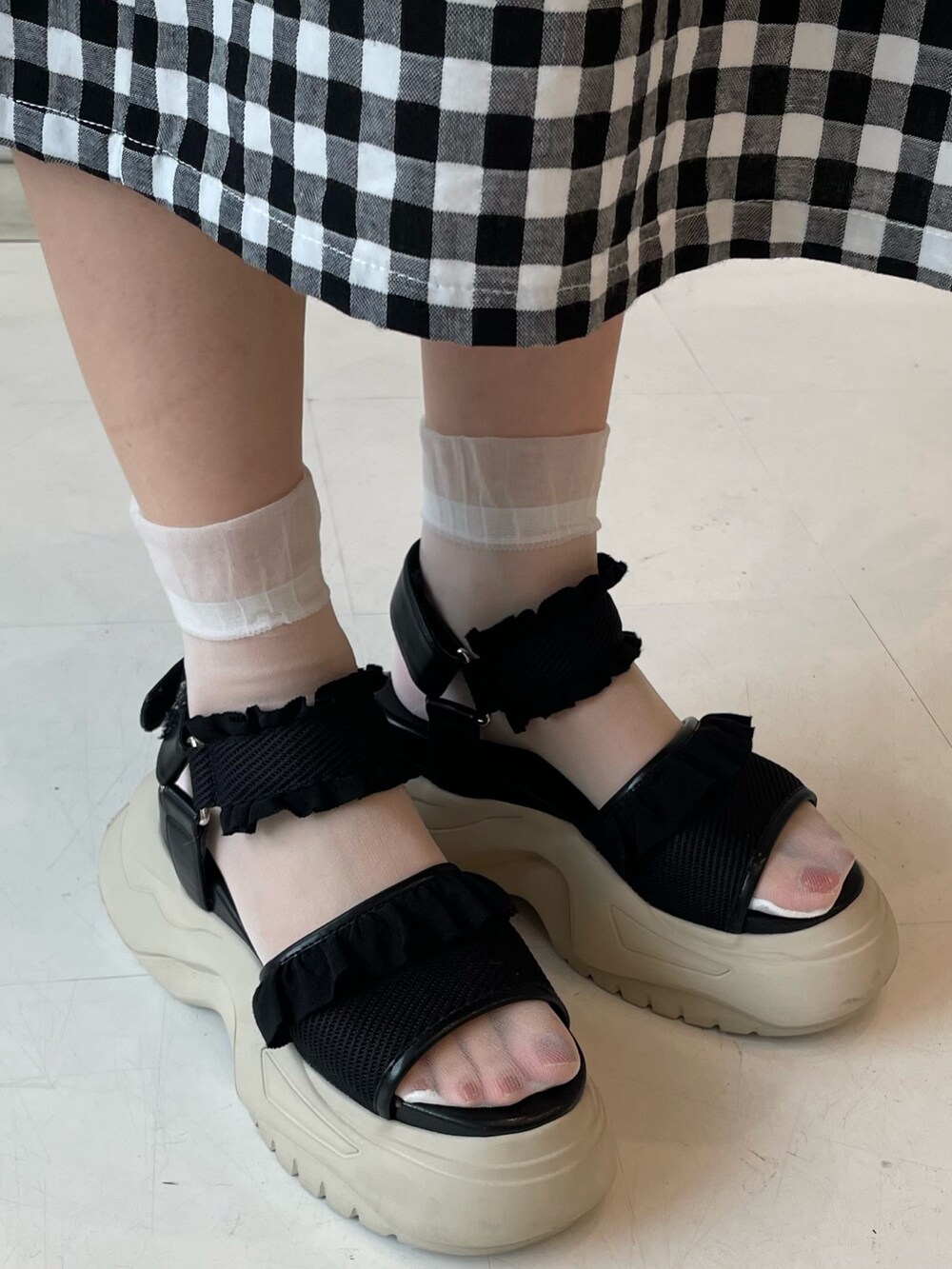 ブラック系のサンダル、ブラック系のワンピース、ブラック系のトートバッグを着用したレディースの夏コーディネートの6枚目の写真