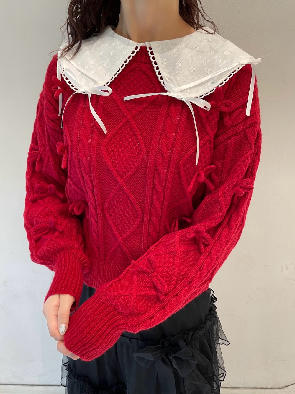 ブラック系のスカート、ホワイト系のシャツ/ブラウス、レッド系のニット/セーターを着用したレディースの冬コーディネートの7枚目の写真