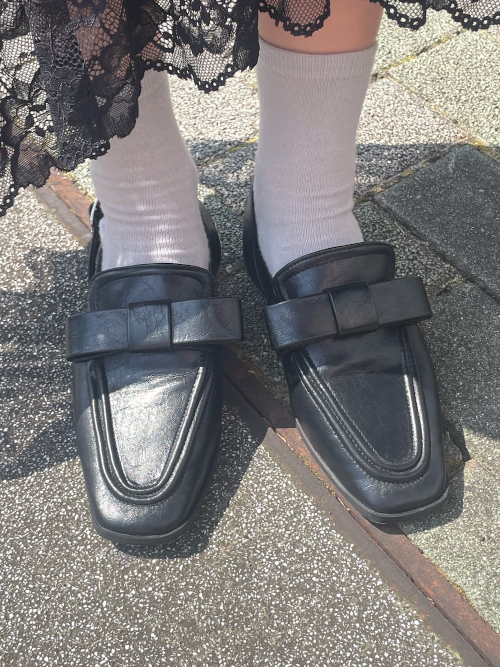 ブラック系のワンピース、ホワイト系のTシャツ/カットソー、ブラック系のローファーを着用したレディースの夏コーディネートの5枚目の写真