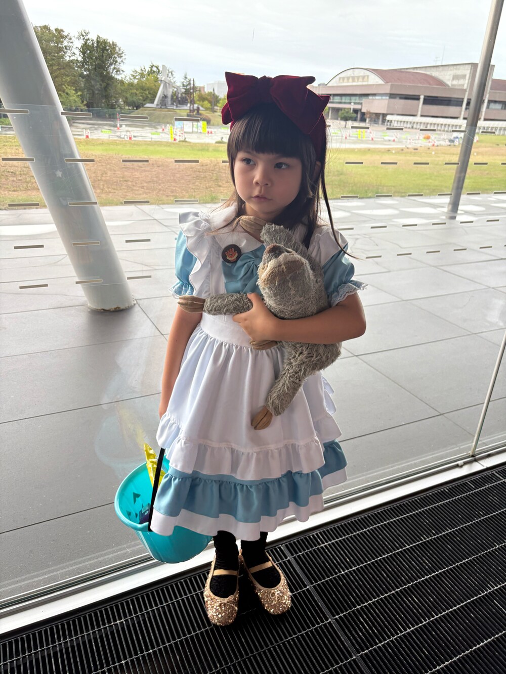 ブルー系のワンピース、ゴールド系のバレエシューズを着用したキッズの秋コーディネートの2枚目の写真