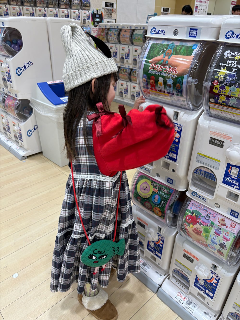 レッド系のスウェット、ブラウン系のブーツ、グリーン系のソックス/靴下を着用したキッズの冬コーディネートの2枚目の写真