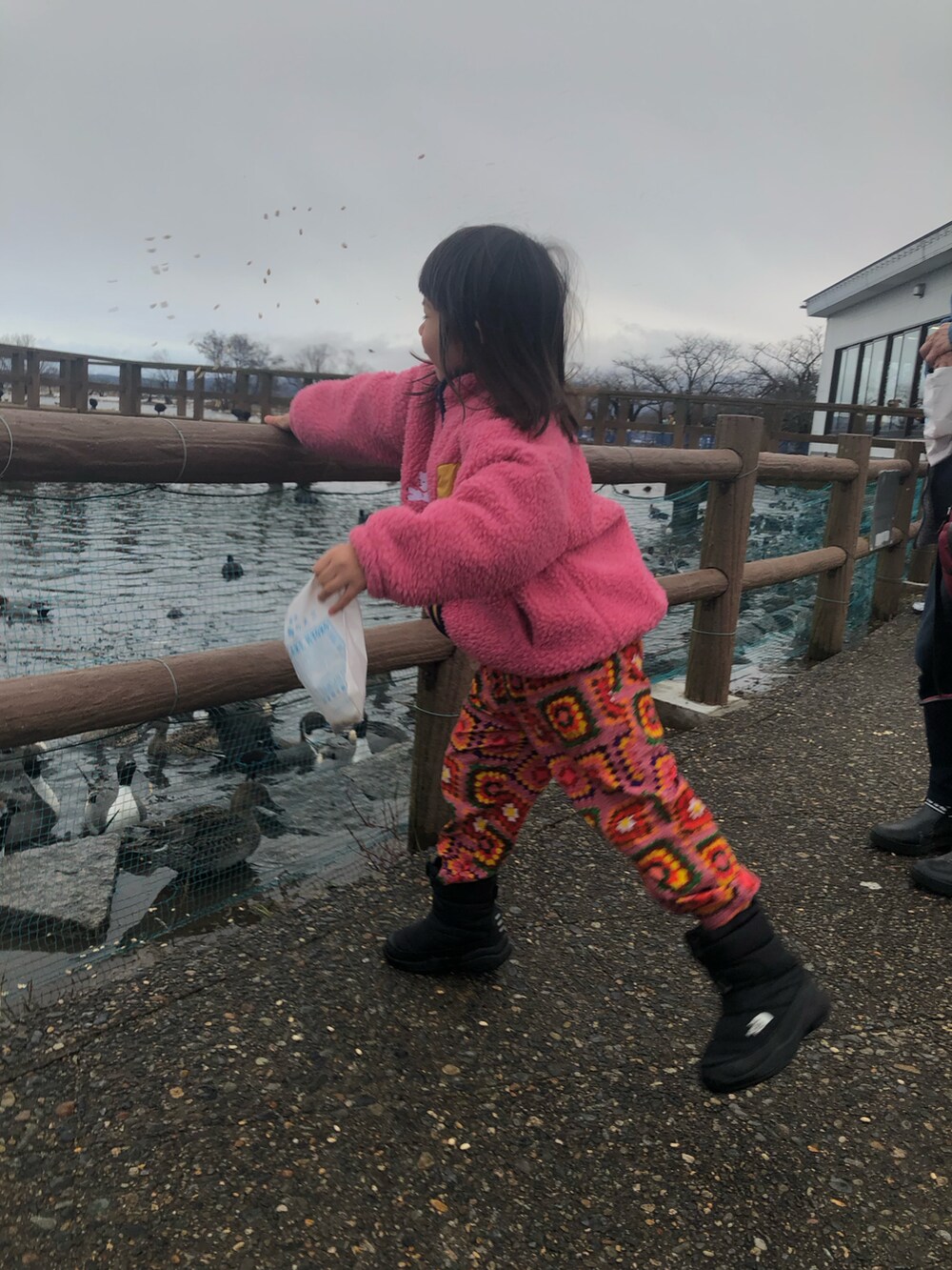 ブラック系のブーツ、ピンク系のその他パンツ、レッド系のスウェットを着用したキッズの冬コーディネートの2枚目の写真