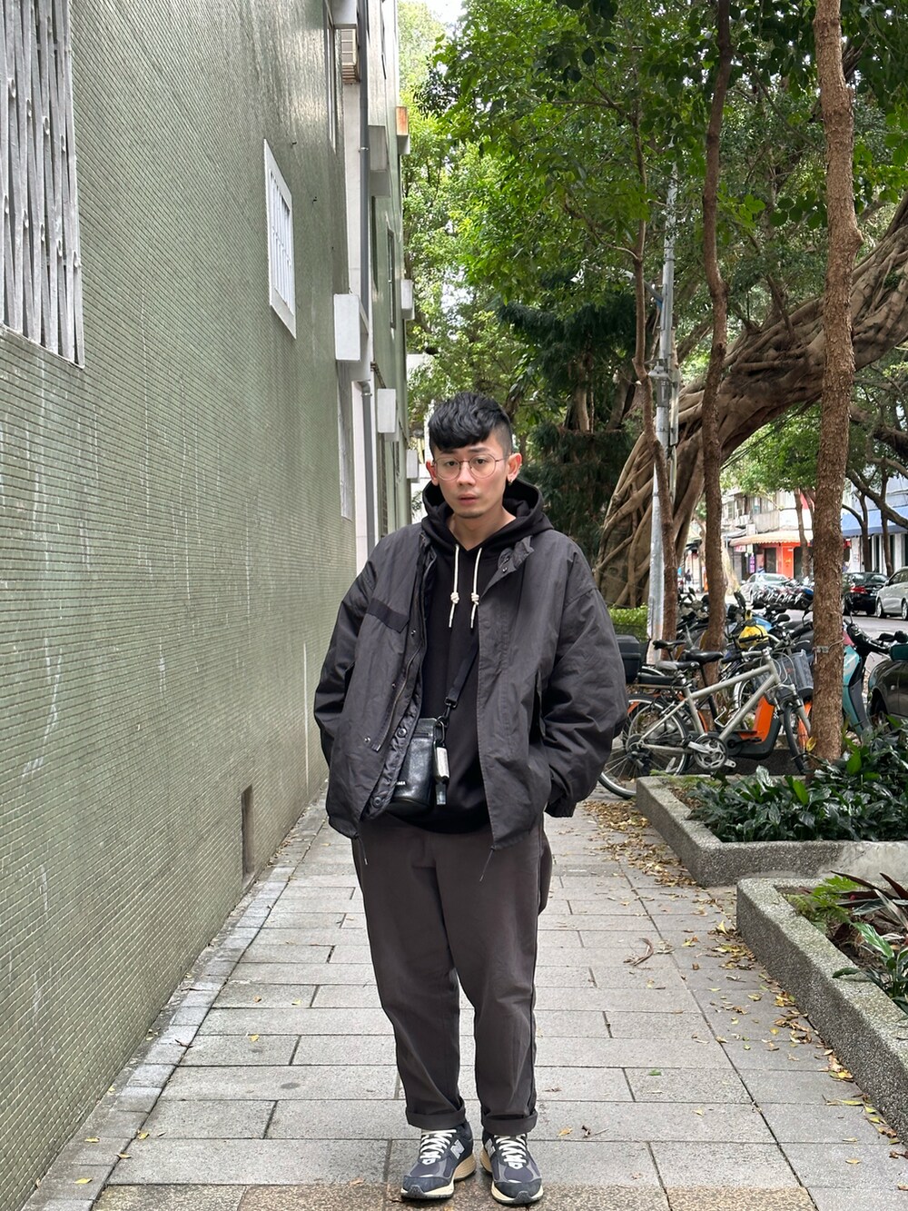 グレー系のチノパンツ、ブラック系のその他トップス、ブラック系のバッグを着用したメンズの冬コーディネートの3枚目の写真