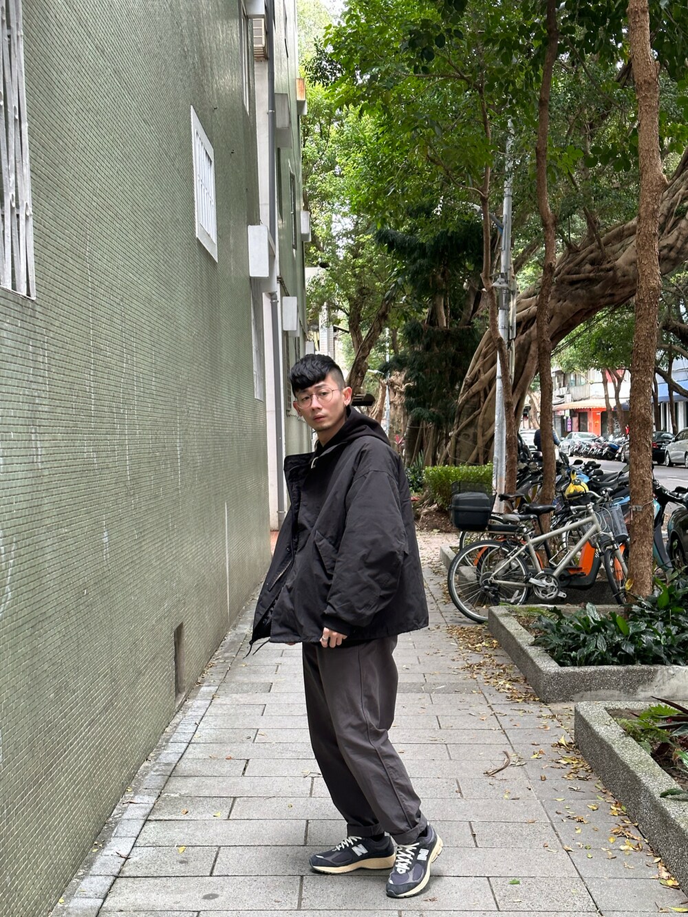 グレー系のチノパンツ、ブラック系のその他トップス、ブラック系のバッグを着用したメンズの冬コーディネートの2枚目の写真