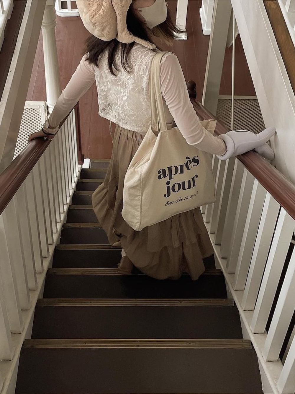 ホワイト系のベスト、ホワイト系のトートバッグ、ベージュ系のスカートを着用したレディースの秋コーディネートの4枚目の写真