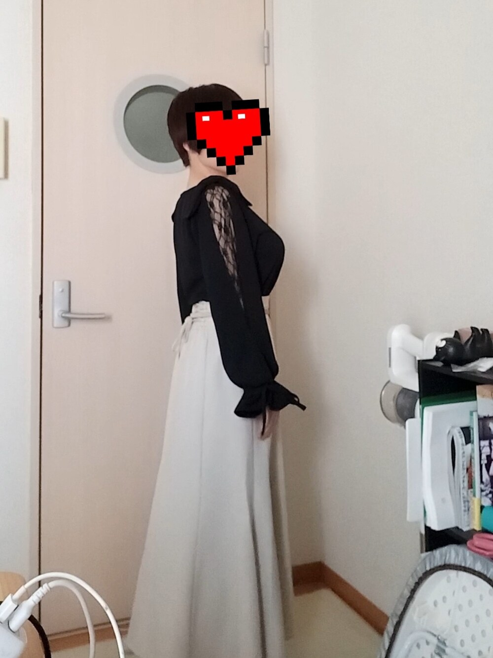 ブラック系のトップス、ホワイト系のスカートを着用したレディースの冬コーディネートの2枚目の写真