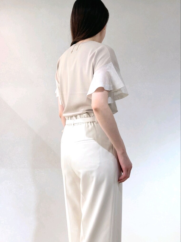 ベージュ系のニット/セーター、ブラック系のトートバッグ、ゴールド系のネックレスを着用したレディースの夏コーディネートの7枚目の写真