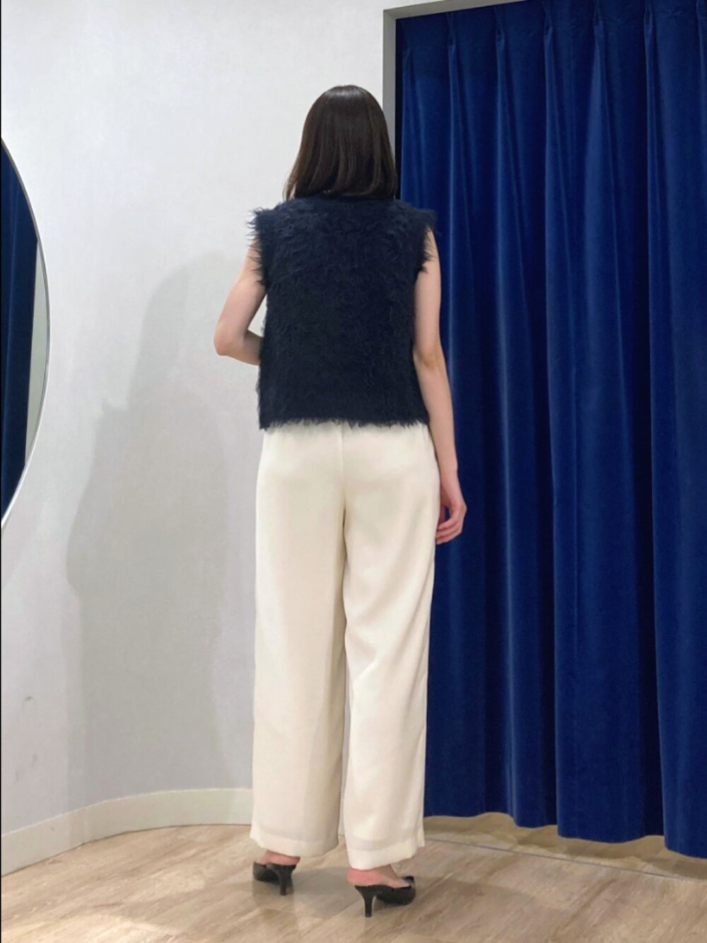 ブルー系のベスト、ブラック系のタンクトップ、ブラウン系のその他パンツを着用したレディースの秋コーディネートの6枚目の写真