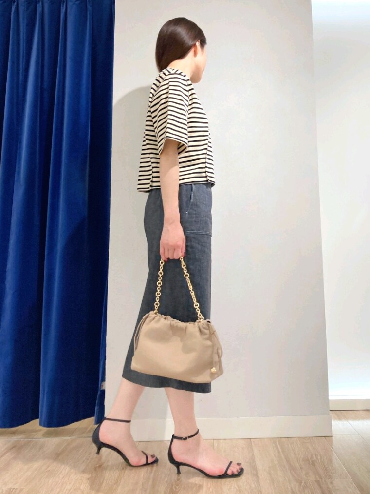 ベージュ系のTシャツ/カットソー、ブルー系のスカート、ベージュ系のショルダーバッグを着用したレディースの夏コーディネートの3枚目の写真