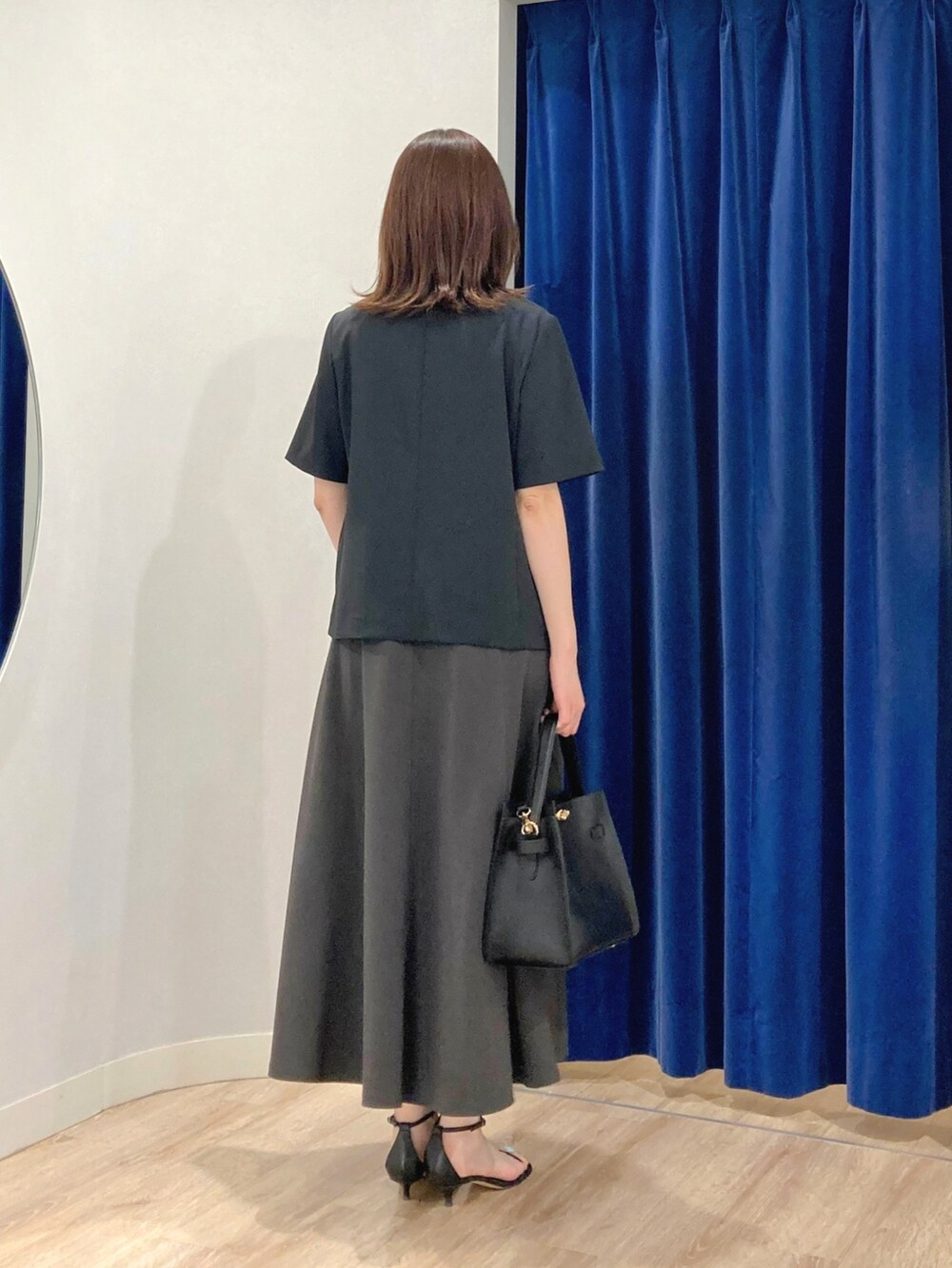 ベージュ系のテーラードジャケット、ブラック系のショルダーバッグ、グレー系のワンピースを着用したレディースの夏コーディネートの5枚目の写真