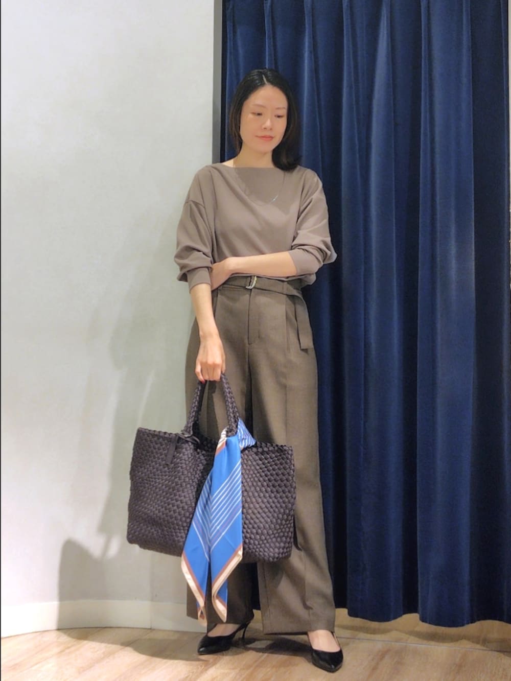 グリーン系のTシャツ/カットソー、ブラウン系のその他パンツ、グレー系のトートバッグを着用したレディースの秋コーディネートの9枚目の写真