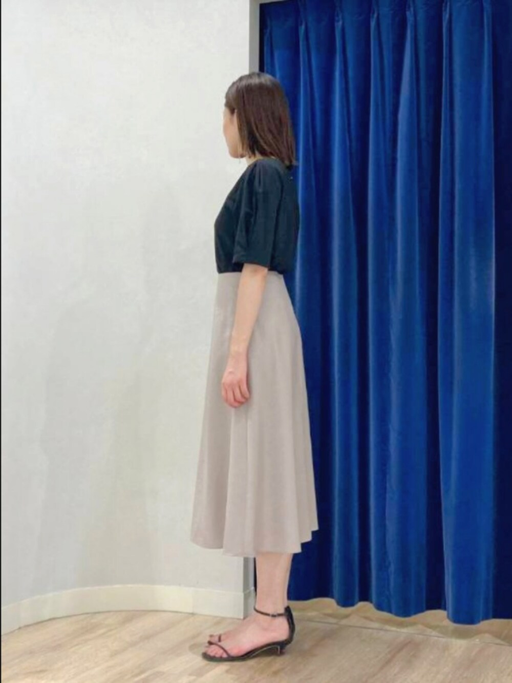 ベージュ系のスカート、ブラック系のTシャツ/カットソー、ゴールド系のピアス（両耳用）を着用したレディースの夏コーディネートの5枚目の写真