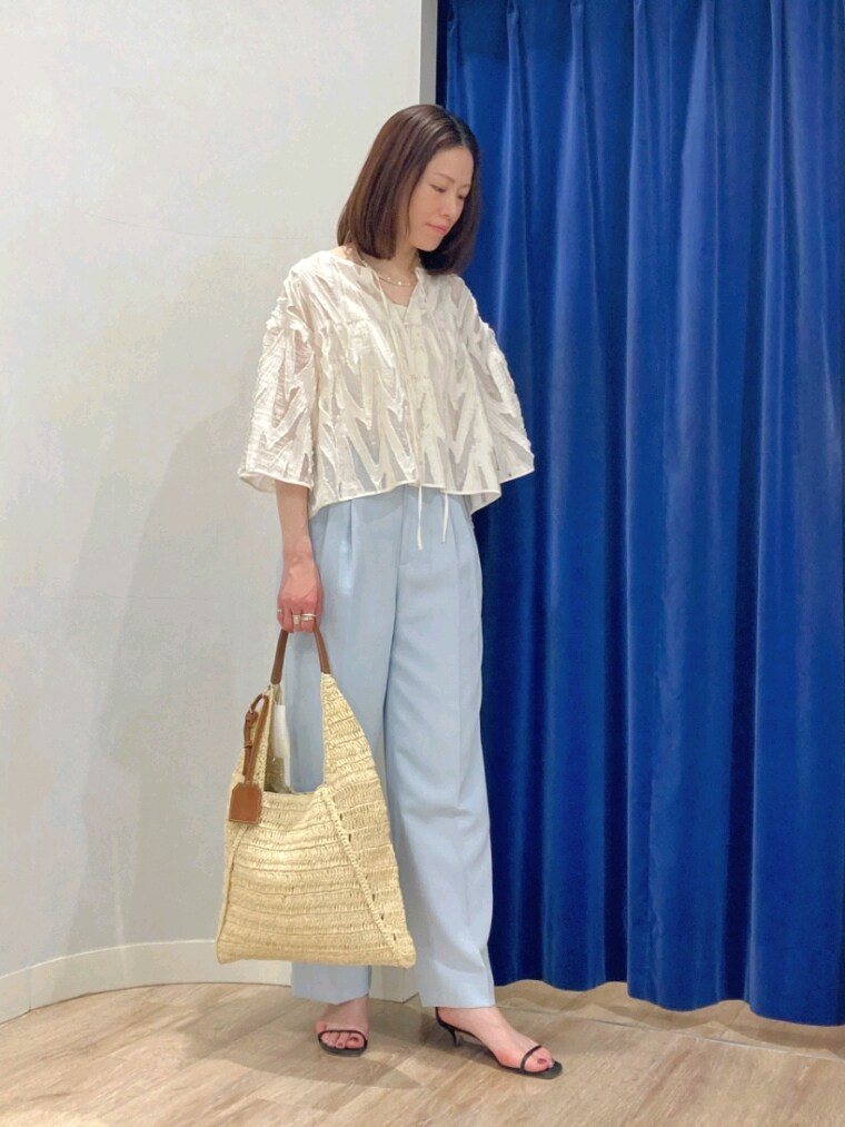 ブルー系のその他パンツ、ホワイト系のシャツ/ブラウス、ベージュ系のショルダーバッグを着用したレディースの春コーディネートの2枚目の写真