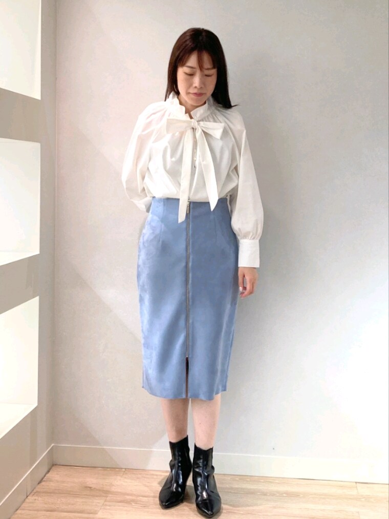 ホワイト系のシャツ/ブラウス、グレー系のカーディガン/ボレロ、ブルー系のスカートを着用したレディースの秋コーディネートの6枚目の写真