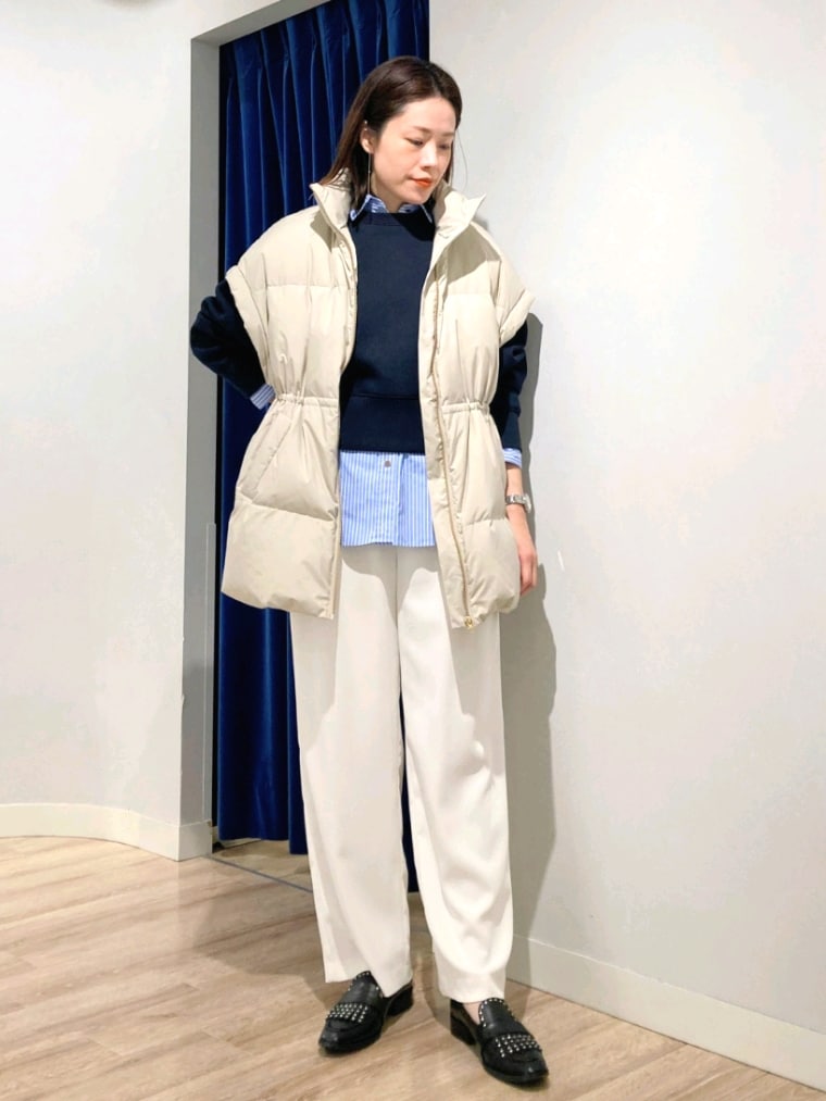 ブルー系のシャツ/ブラウス、ブルー系のTシャツ/カットソー、ベージュ系のダウンベストを着用したレディースの秋コーディネートの2枚目の写真