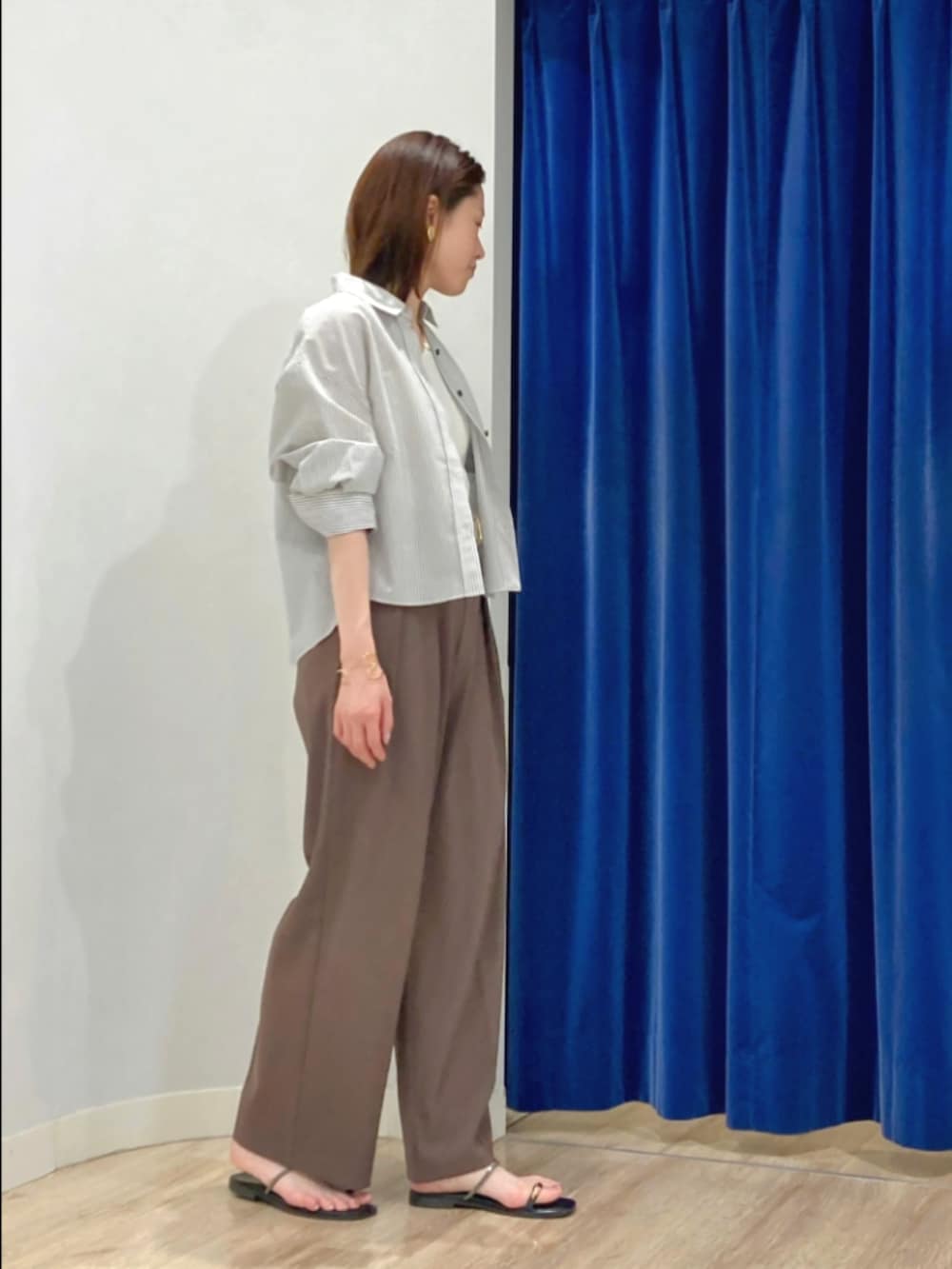 ブラウン系のその他パンツ、ゴールド系のサンダル、ベージュ系のシャツ/ブラウスを着用したレディースの夏コーディネートの3枚目の写真