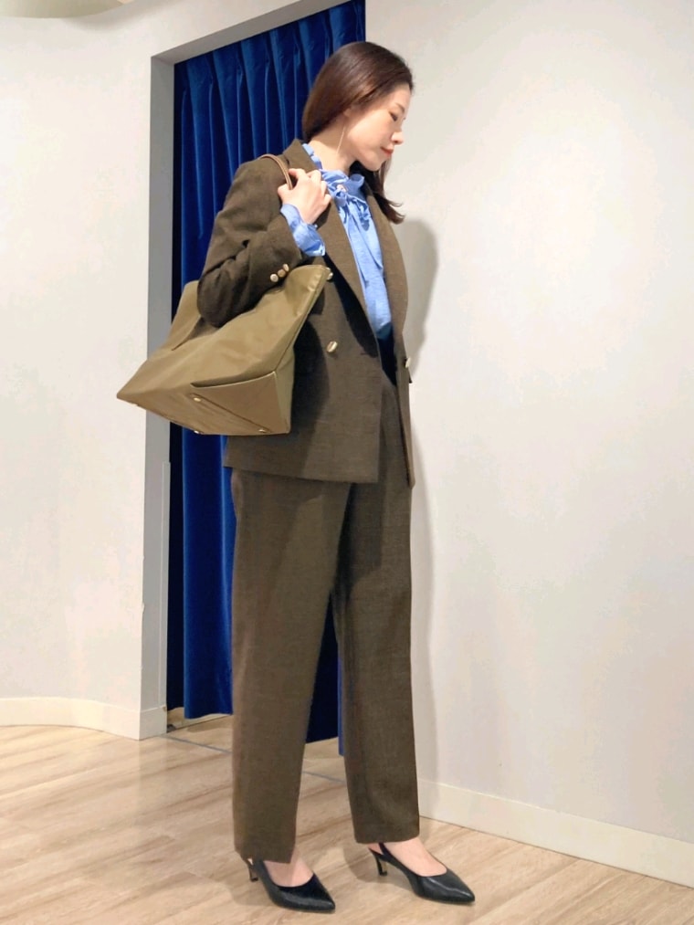 ブラウン系のテーラードジャケット、ブルー系のシャツ/ブラウス、ブラウン系のその他パンツを着用したレディースの秋コーディネートの4枚目の写真
