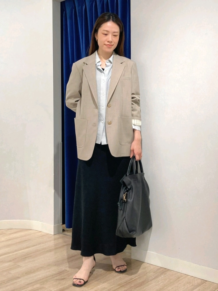 グリーン系のシャツ/ブラウス、ベージュ系のテーラードジャケット、ブラック系のスカートを着用したレディースの秋コーディネートの9枚目の写真