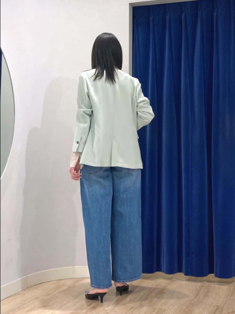 グリーン系のノーカラージャケット、ホワイト系のTシャツ/カットソー、ブルー系のデニムパンツを着用したレディースの冬コーディネートの5枚目の写真