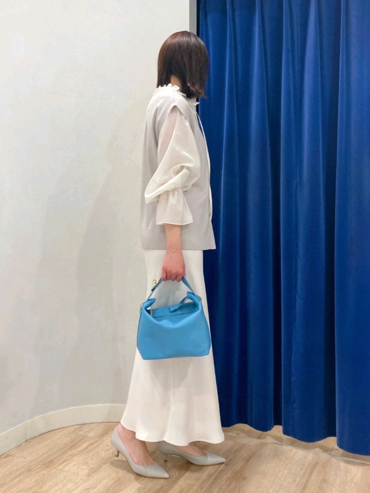 ホワイト系のシャツ/ブラウス、ベージュ系のニット/セーター、ホワイト系のスカートを着用したレディースの春コーディネートの3枚目の写真