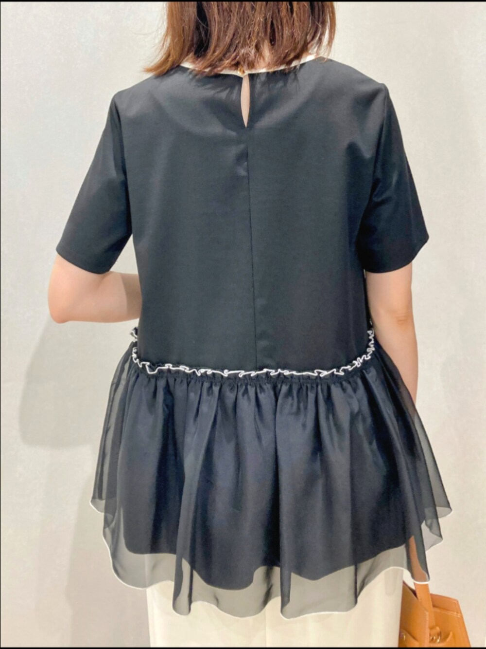 ブラック系のTシャツ/カットソー、ブラック系のショルダーバッグ、ホワイト系のスカートを着用したレディースの夏コーディネートの8枚目の写真