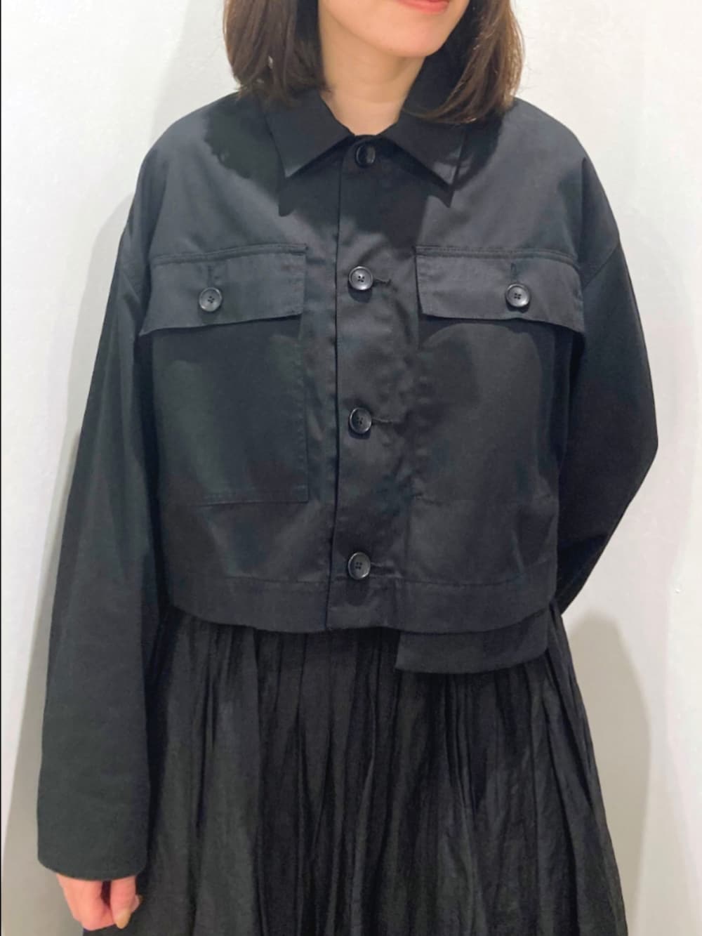 ブラック系のスカート、ブラック系のブルゾン、ベージュ系のショルダーバッグを着用したレディースの秋コーディネートの8枚目の写真