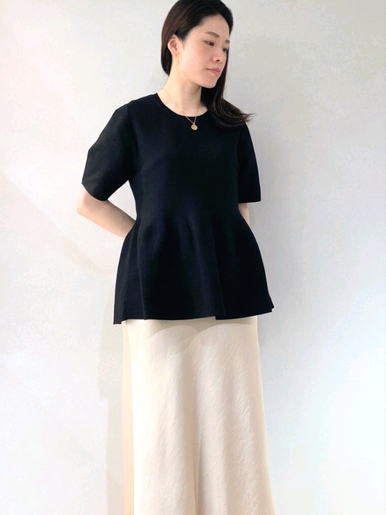 ブラック系のニット/セーター、ベージュ系のショルダーバッグ、ベージュ系のスカートを着用したレディースの春コーディネートの7枚目の写真