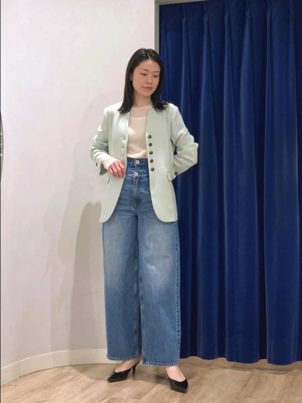 グリーン系のノーカラージャケット、ホワイト系のTシャツ/カットソー、ブルー系のデニムパンツを着用したレディースの冬コーディネートの2枚目の写真