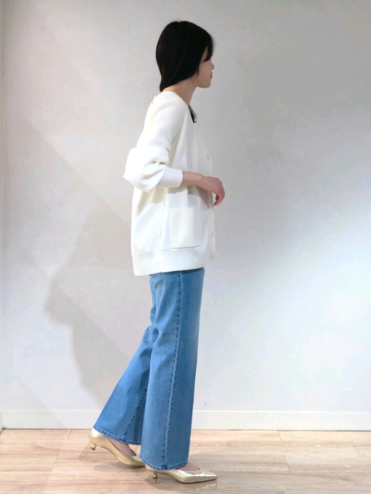 ホワイト系のニット/セーター、ゴールド系のキャミソール、ブルー系のデニムパンツを着用したレディースの春コーディネートの5枚目の写真