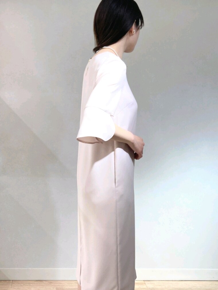 ピンク系のワンピース、ゴールド系のパンプス、ホワイト系のショルダーバッグを着用したレディースの春コーディネートの5枚目の写真