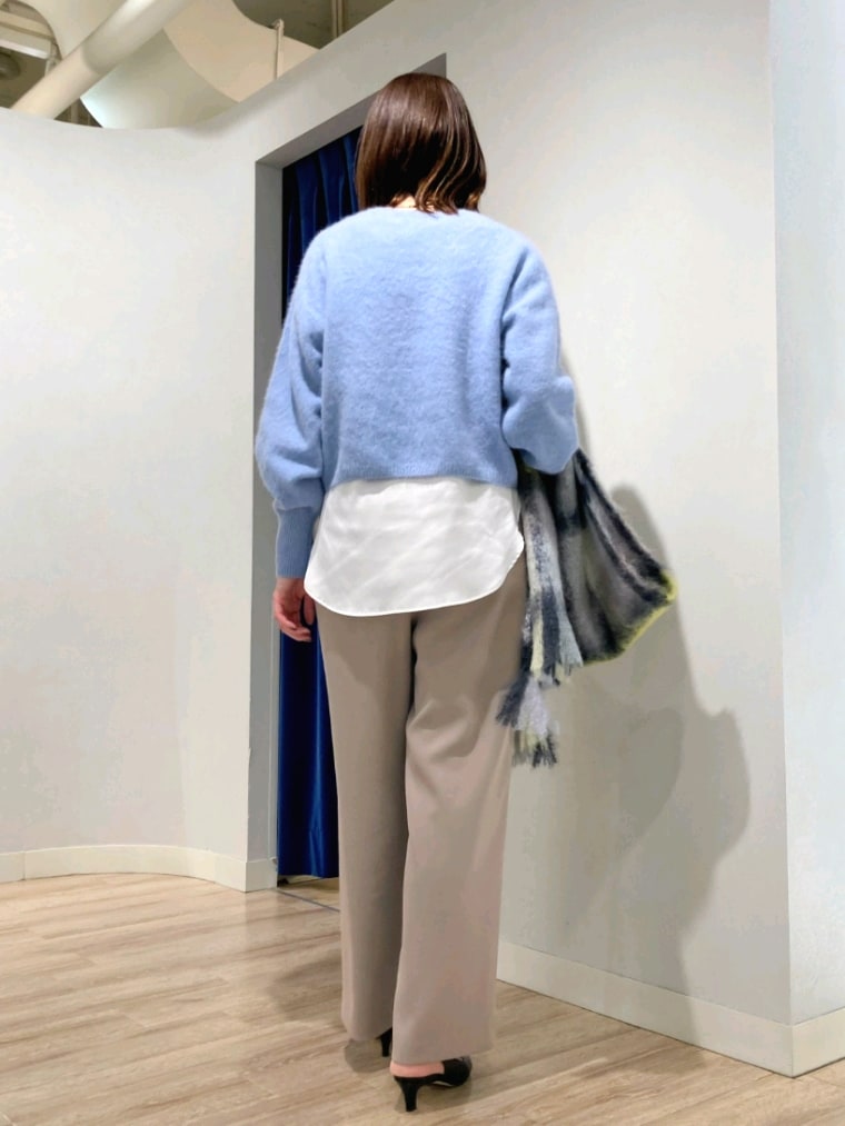 ブルー系のニット/セーター、ホワイト系のシャツ/ブラウス、ベージュ系のその他パンツを着用したレディースの秋コーディネートの4枚目の写真