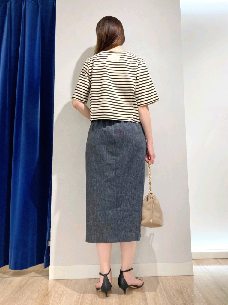 ベージュ系のTシャツ/カットソー、ブルー系のスカート、ベージュ系のショルダーバッグを着用したレディースの夏コーディネートの4枚目の写真