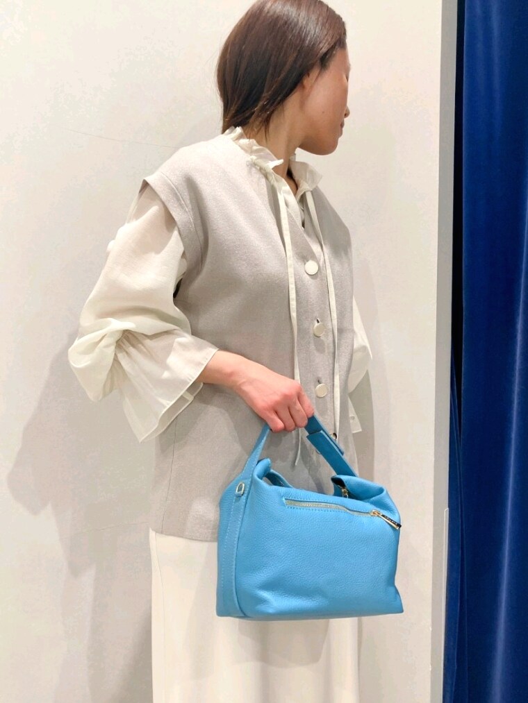 ホワイト系のシャツ/ブラウス、ベージュ系のニット/セーター、ホワイト系のスカートを着用したレディースの春コーディネートの6枚目の写真