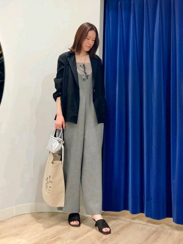 ブラック系のテーラードジャケット、グリーン系のキャミソール、グレー系のつなぎ/オールインワンを着用したレディースの春コーディネートの3枚目の写真