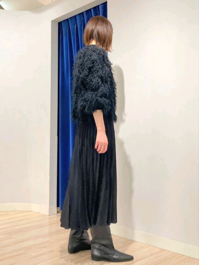 ブラック系のニット/セーター、グレー系のバッグ、ホワイト系のダウンジャケット/コートを着用したレディースの秋コーディネートの4枚目の写真