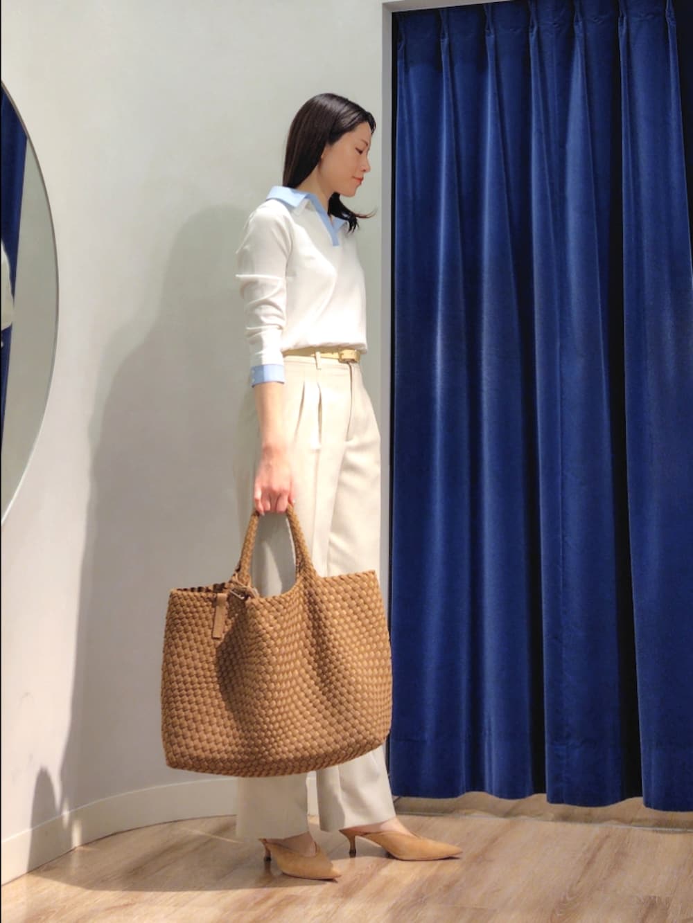 ブラウン系のトートバッグ、ベージュ系のその他パンツ、ホワイト系のニット/セーターを着用したレディースの春コーディネートの2枚目の写真