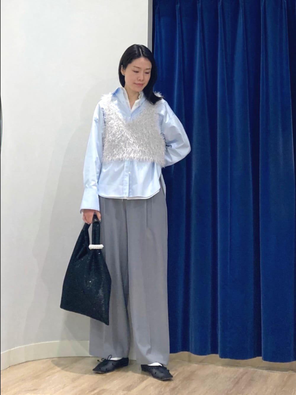 ブルー系のシャツ/ブラウス、シルバー系のニット/セーター、グレー系のその他パンツを着用したレディースの冬コーディネートの2枚目の写真