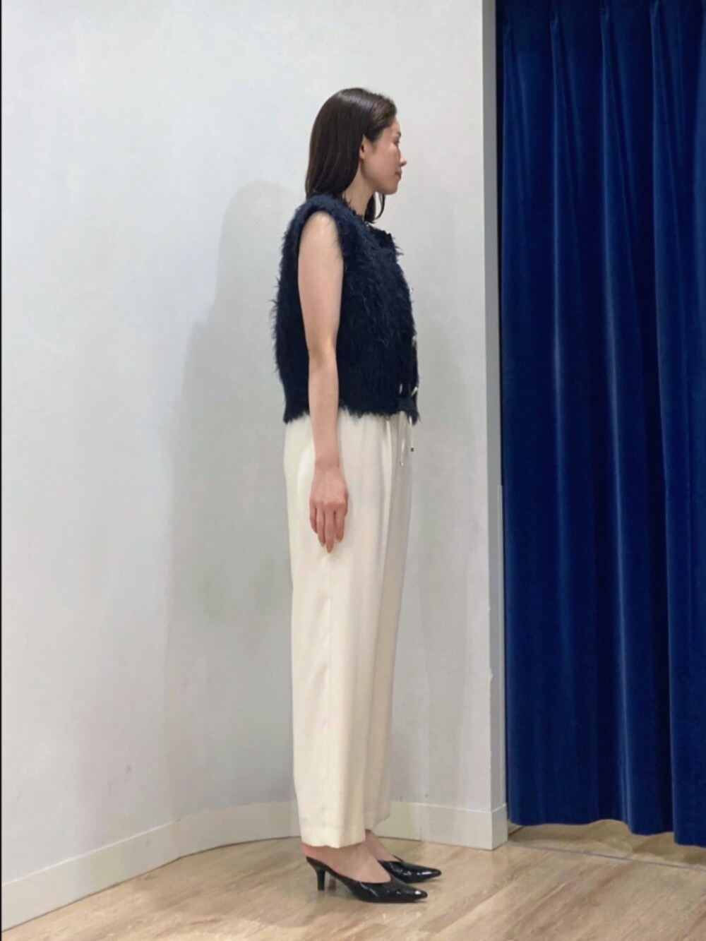 ブルー系のベスト、ブラック系のタンクトップ、ブラウン系のその他パンツを着用したレディースの秋コーディネートの5枚目の写真