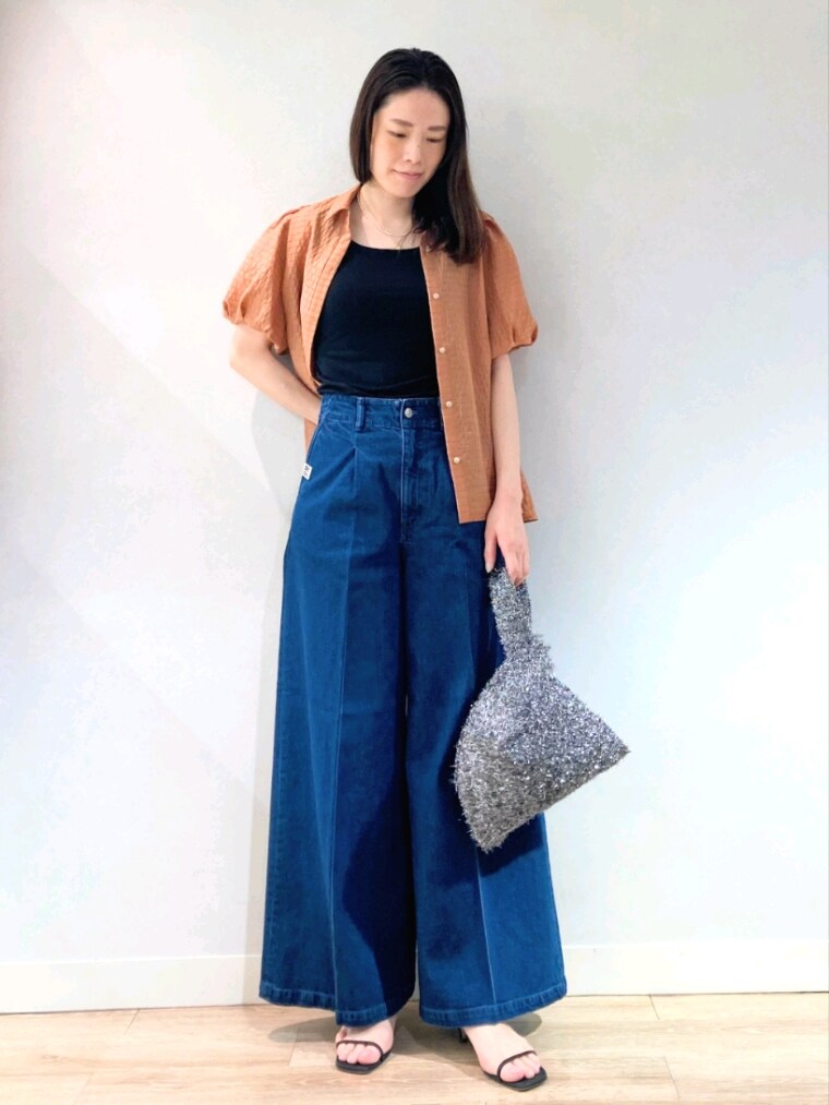 イエロー系のシャツ/ブラウス、ブラック系のタンクトップ、ブルー系のデニムパンツを着用したレディースの夏コーディネートの2枚目の写真